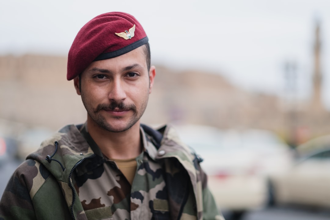 man in green camouflage jacket and red knit cap