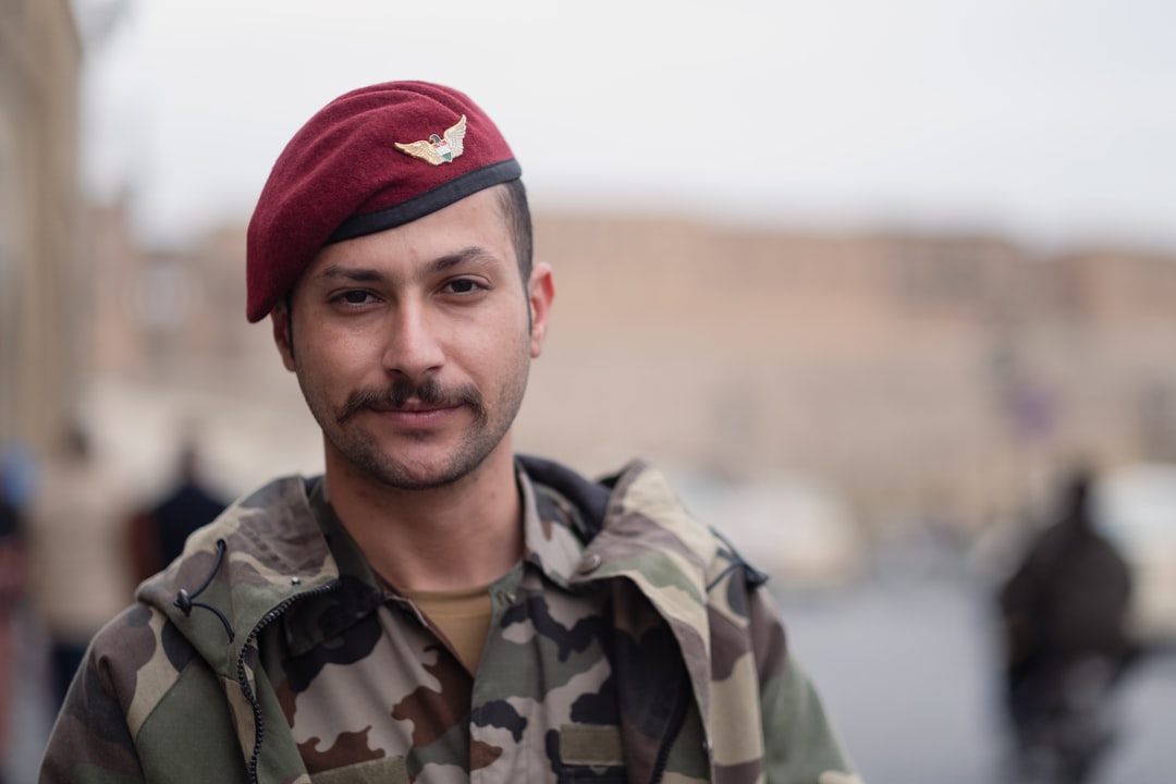 man in green camouflage jacket and red knit cap