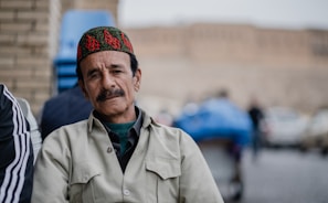 man in gray button up shirt wearing blue and red knit cap