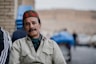 man in gray button up shirt wearing blue and red knit cap