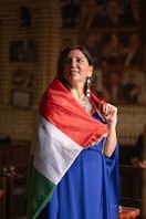 woman in blue white and red long sleeve shirt holding white and red flag