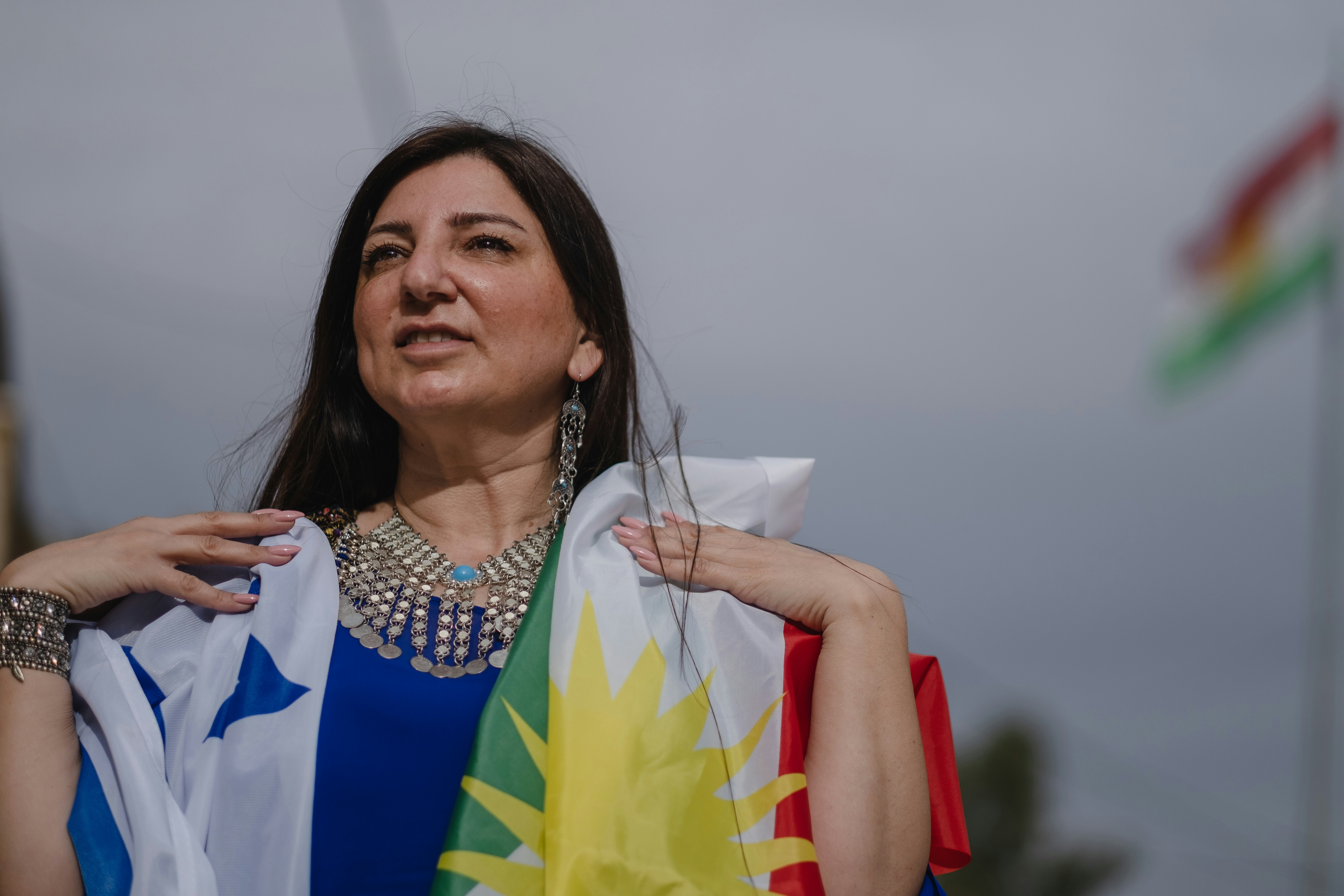 Mujer con camisa blanca y negra sosteniendo bandera blanca y amarilla