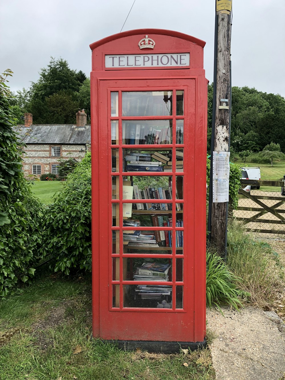 red telephone booth near green grass during daytime