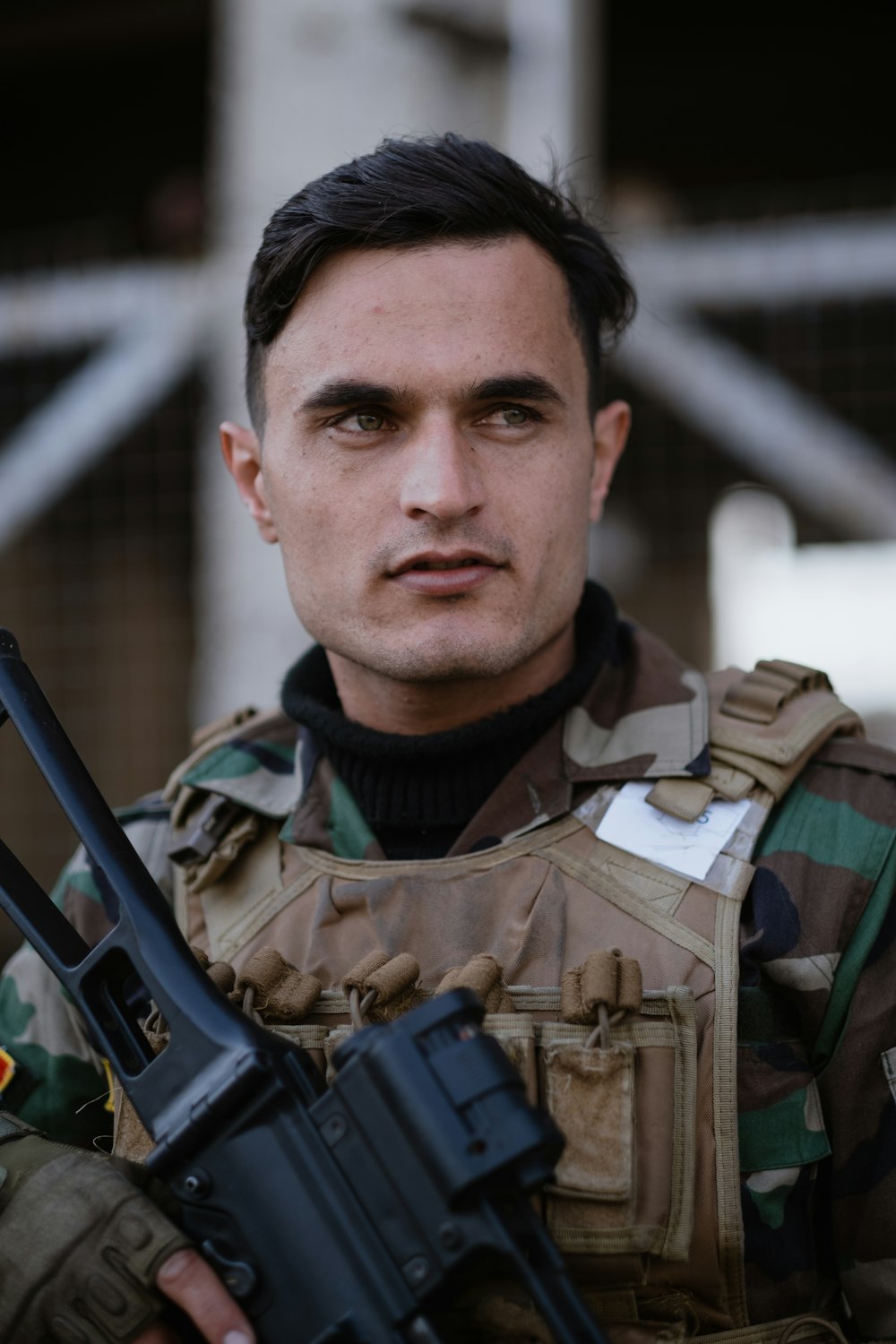 man in green and brown camouflage uniform holding black rifle