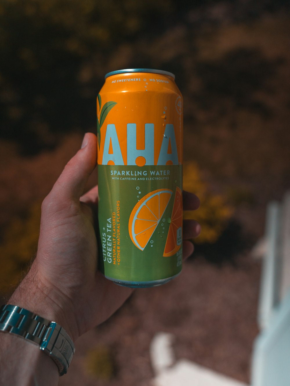 person holding orange and green fanta can