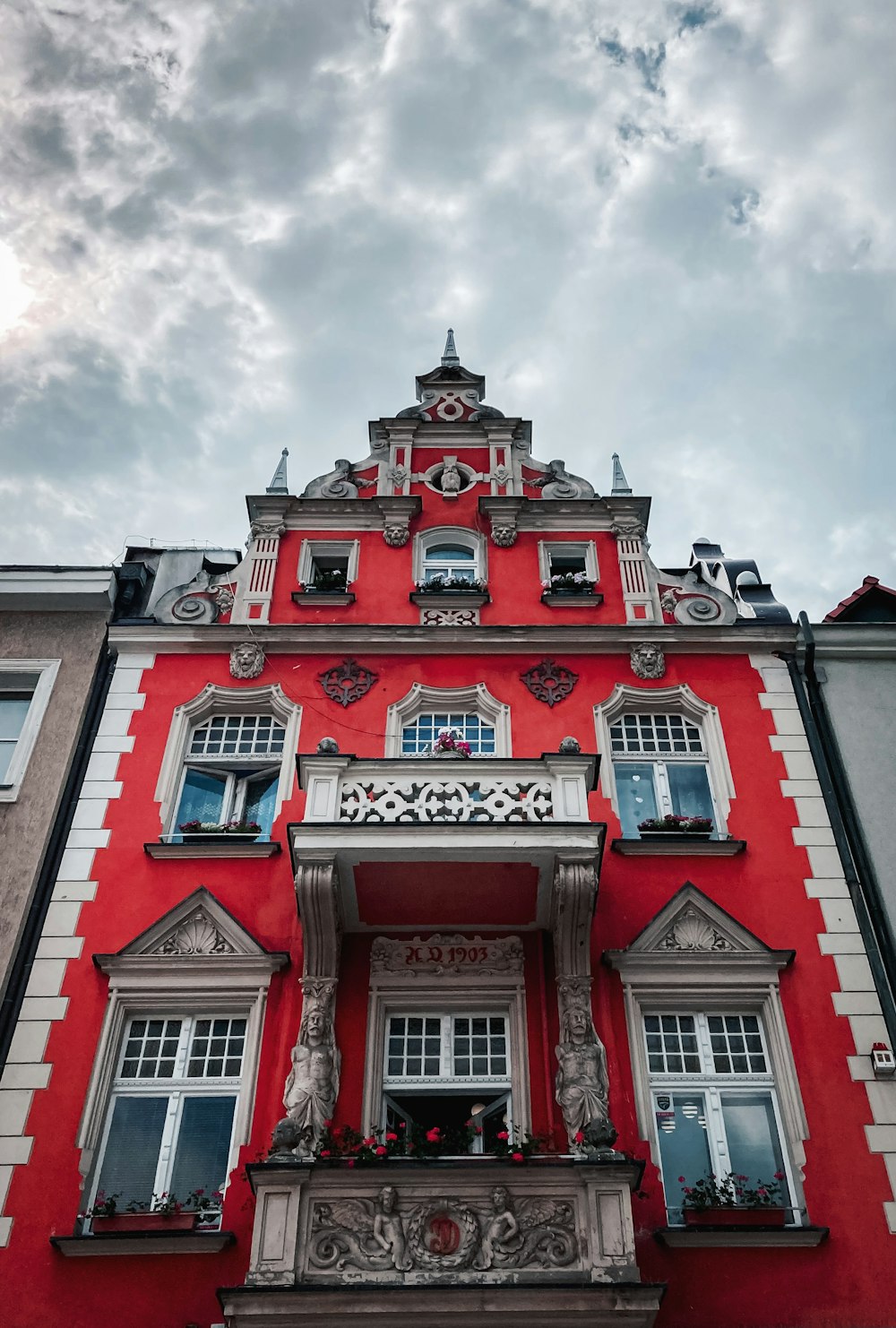 Edificio de hormigón rojo y blanco bajo nubes blancas durante el día