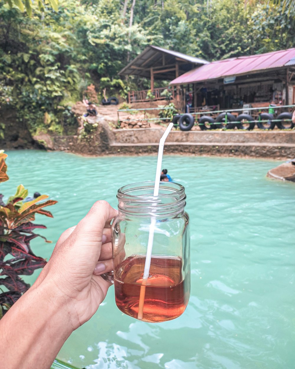 person holding clear glass cup with brown liquid