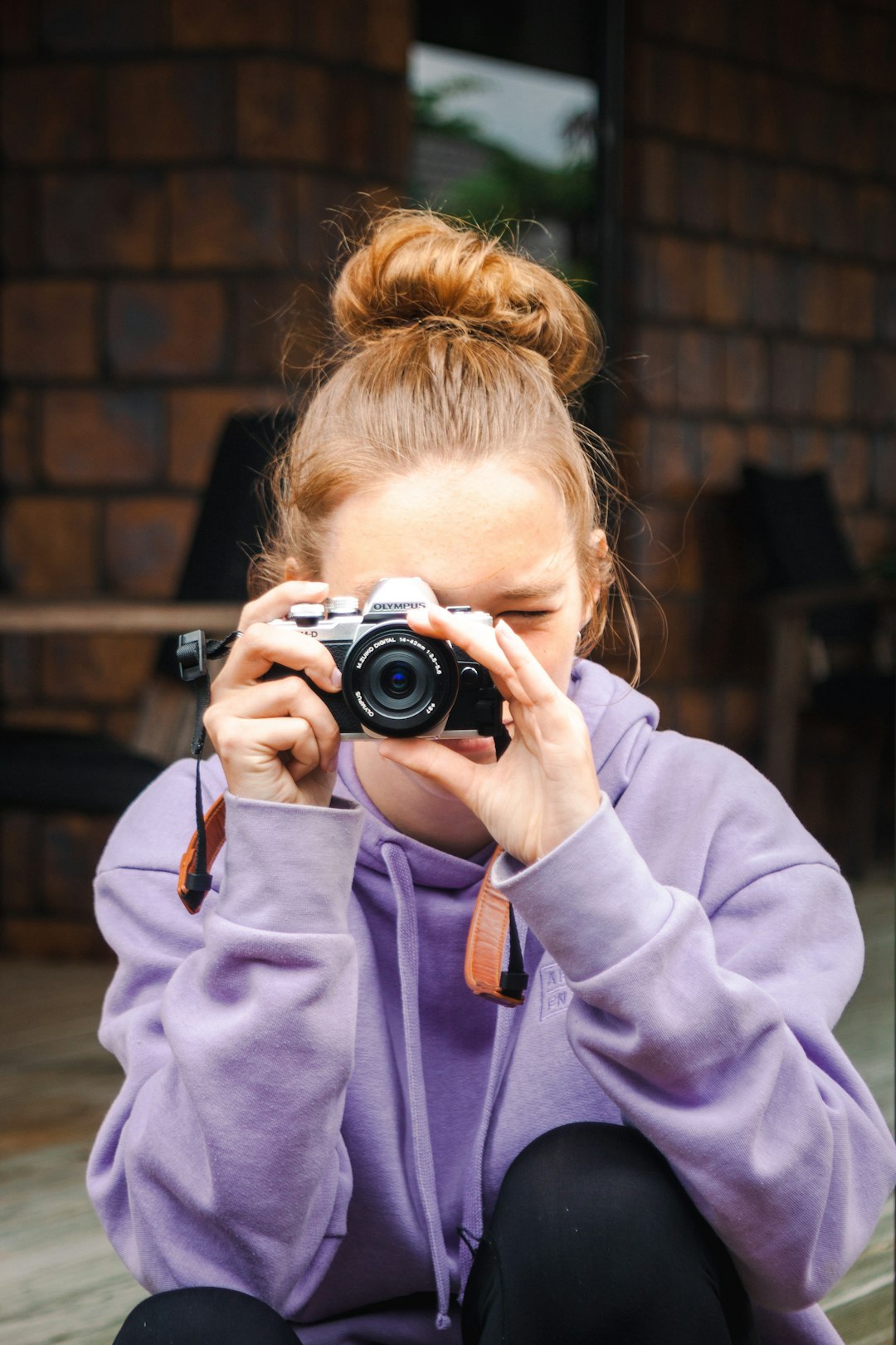 woman in blue jacket holding black and silver camera