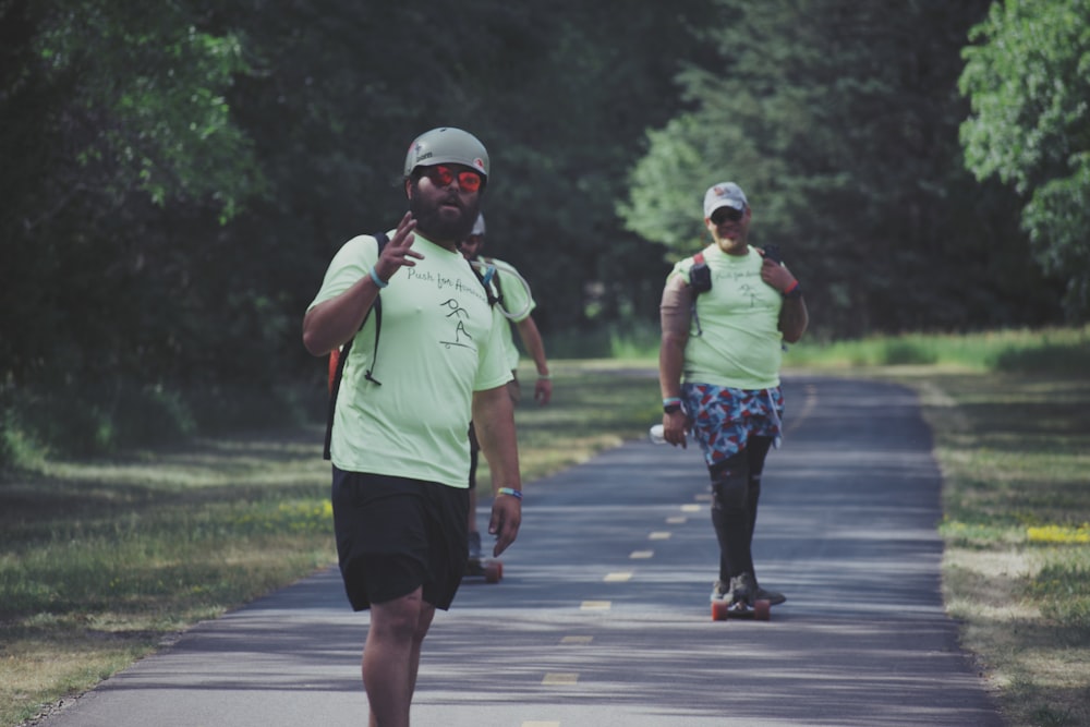 man in green crew neck t-shirt and black shorts running on road during daytime