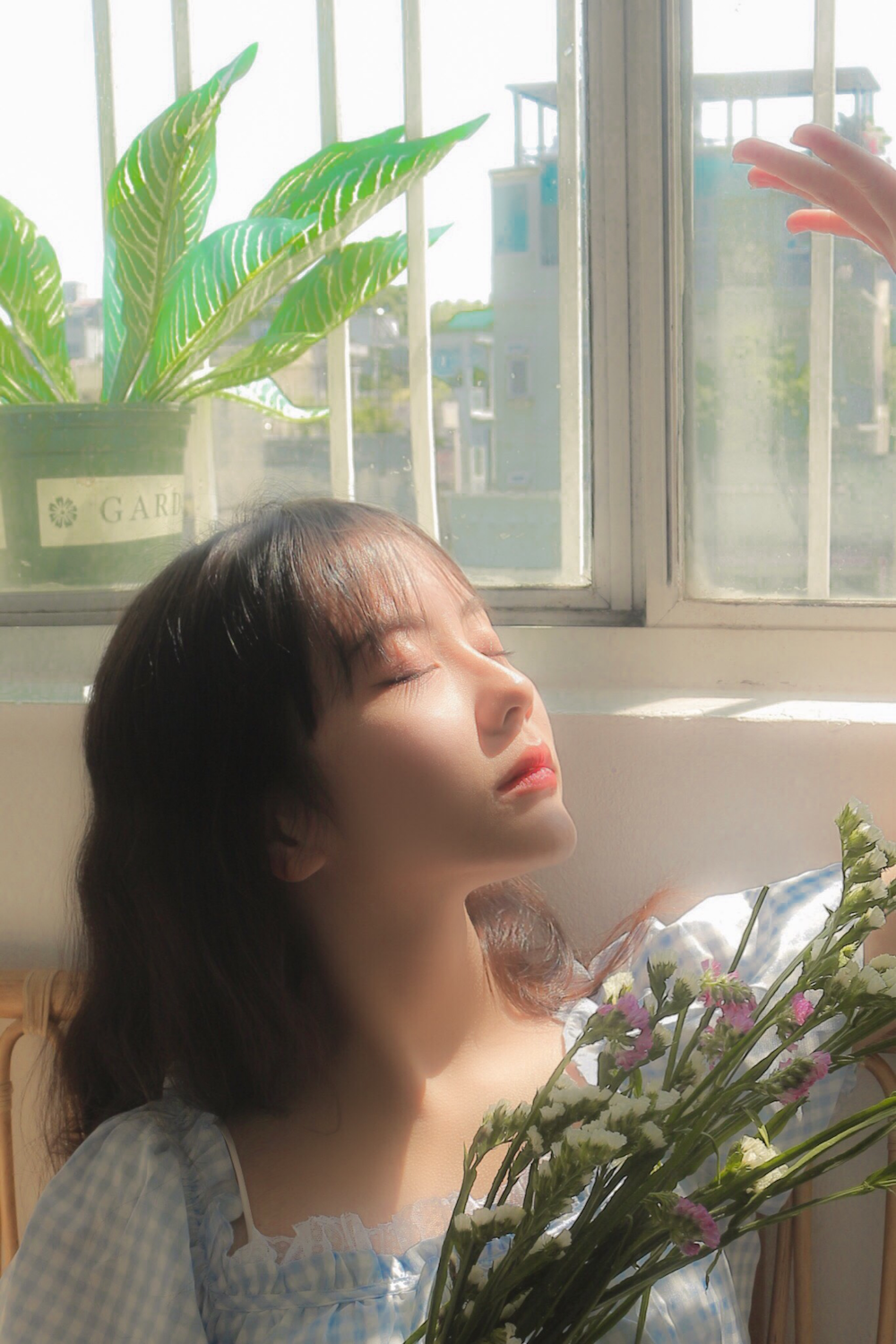 woman in white shirt sitting beside window