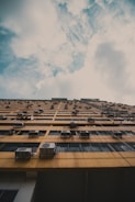 brown concrete building under white clouds during daytime
