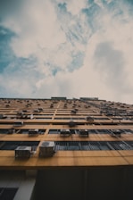 brown concrete building under white clouds during daytime