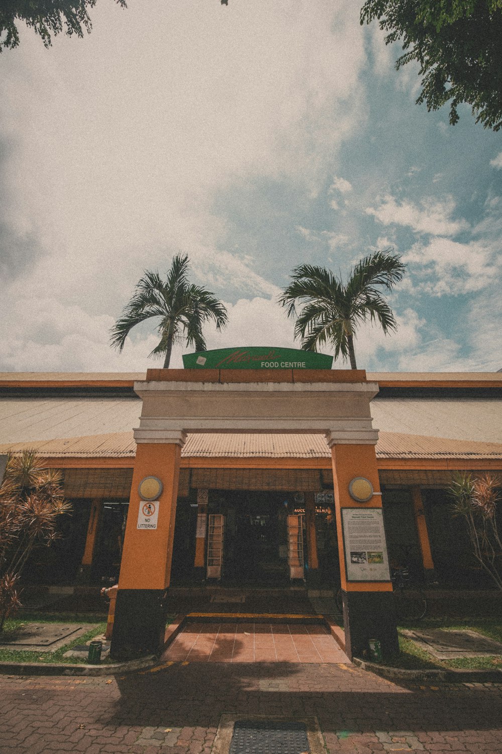 brown and white concrete building near palm trees during daytime