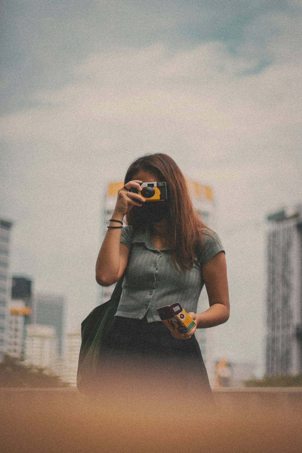 woman in gray shirt holding orange and white cup