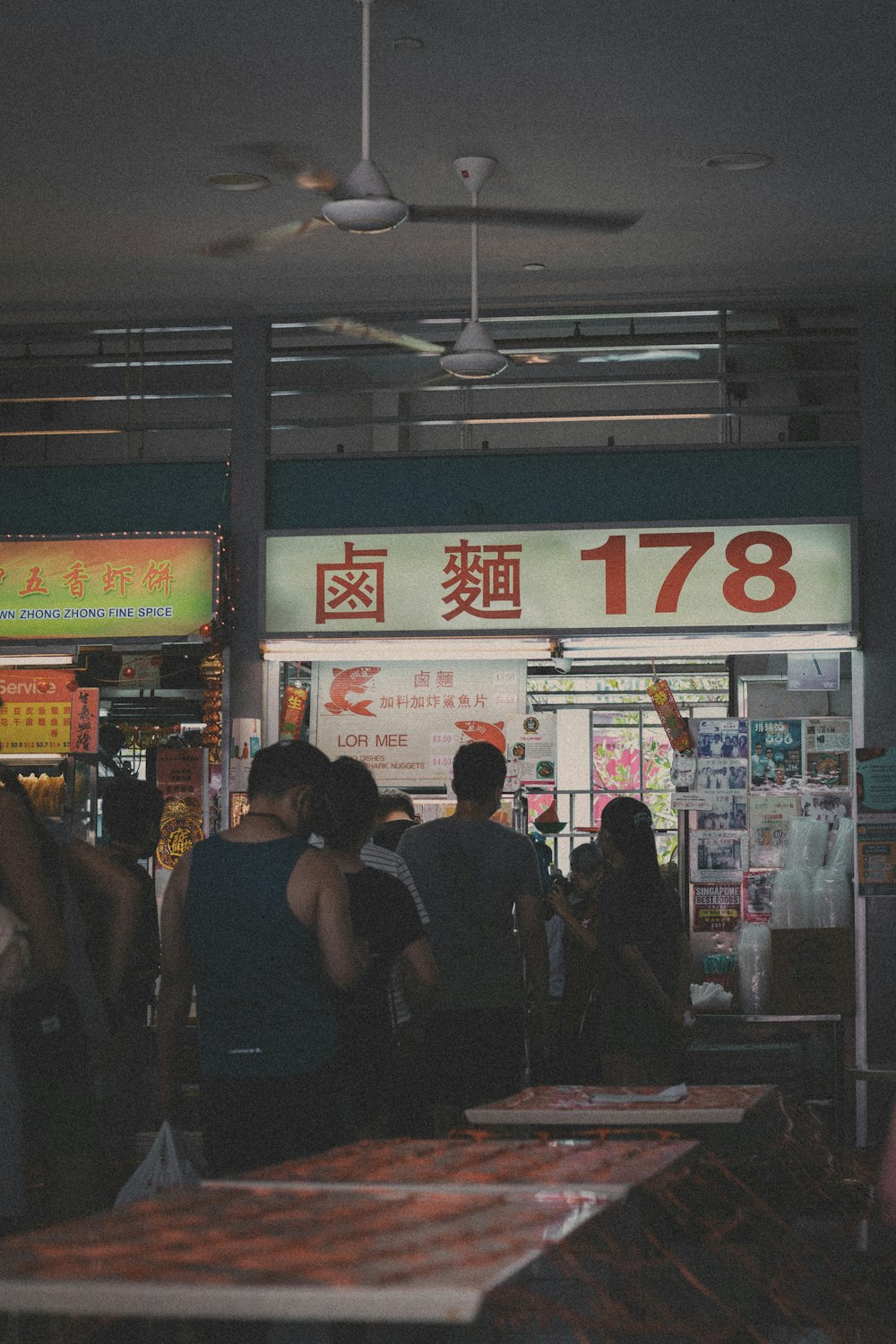 people standing near red and white store during nighttime