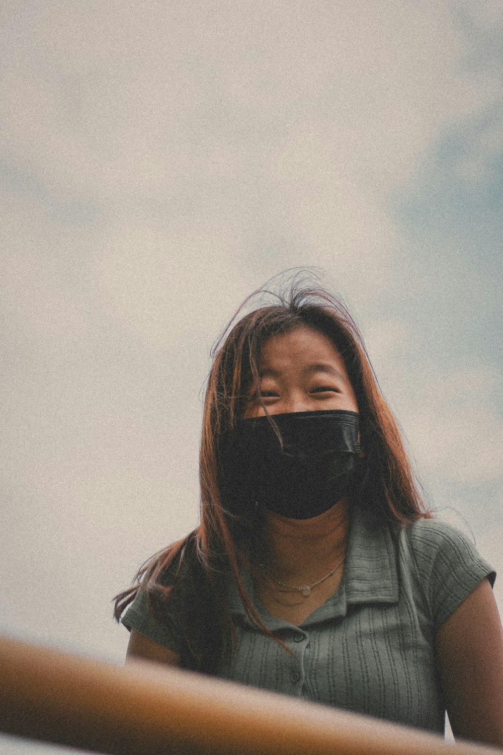 woman in gray shirt covering her face with her hair