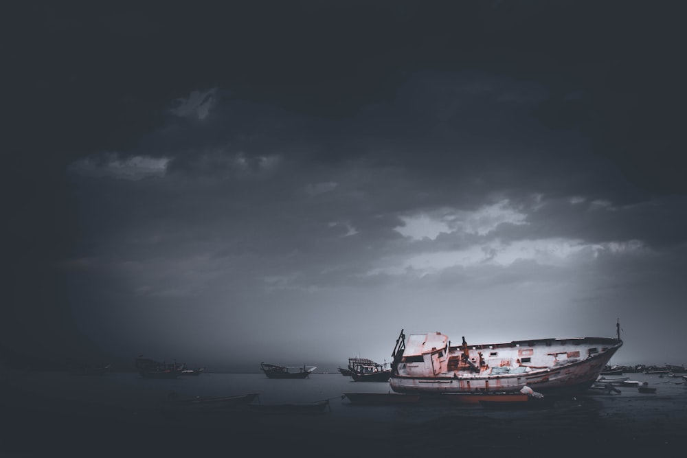rot-weißes Boot auf See unter grauen Wolken