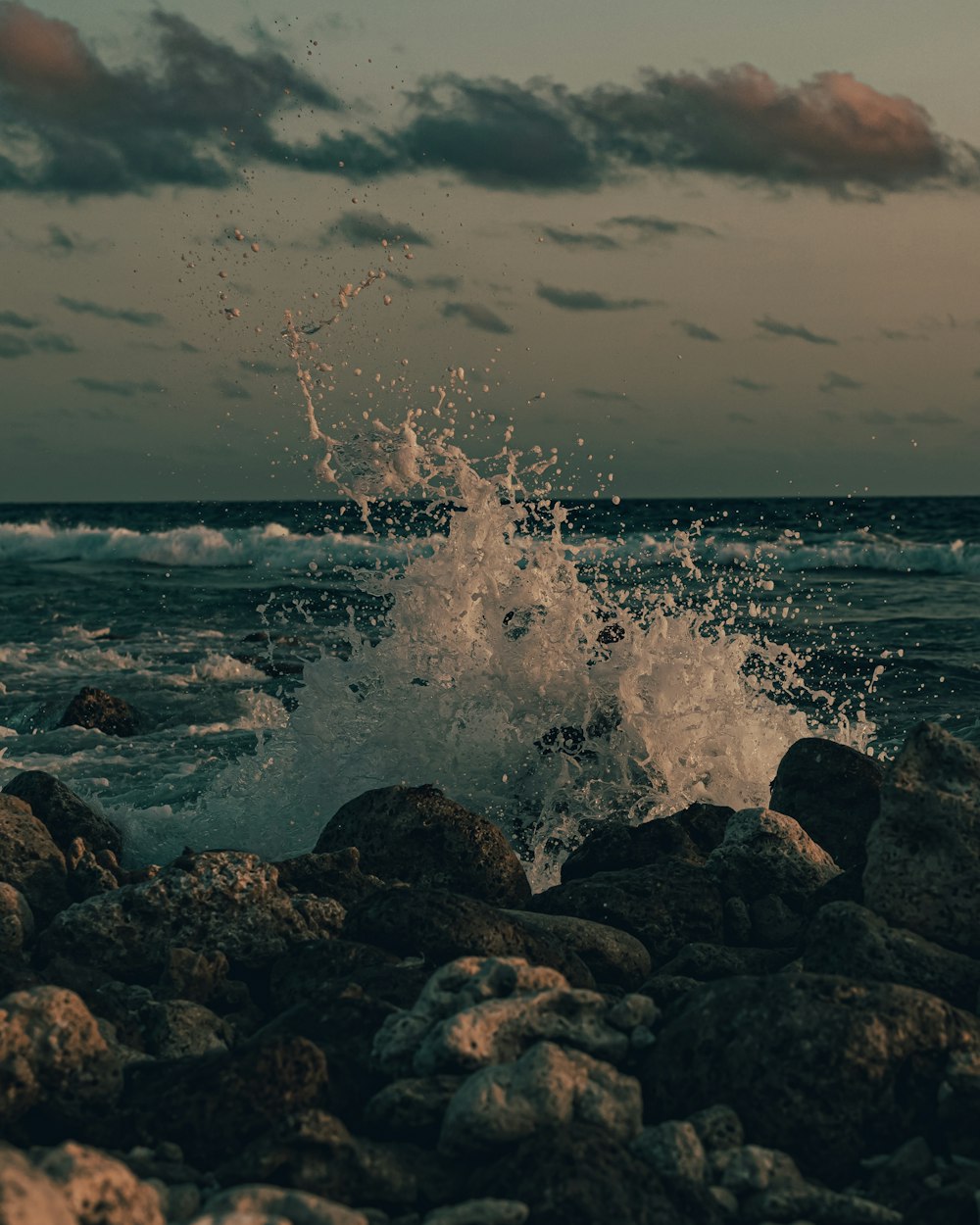 sea waves crashing on rocks during daytime