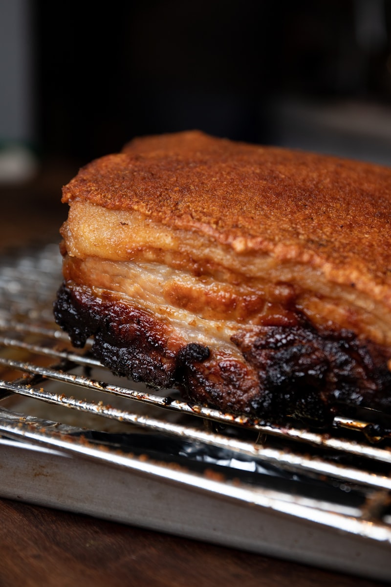 Roast pork with deep golden crackling resting on a rack