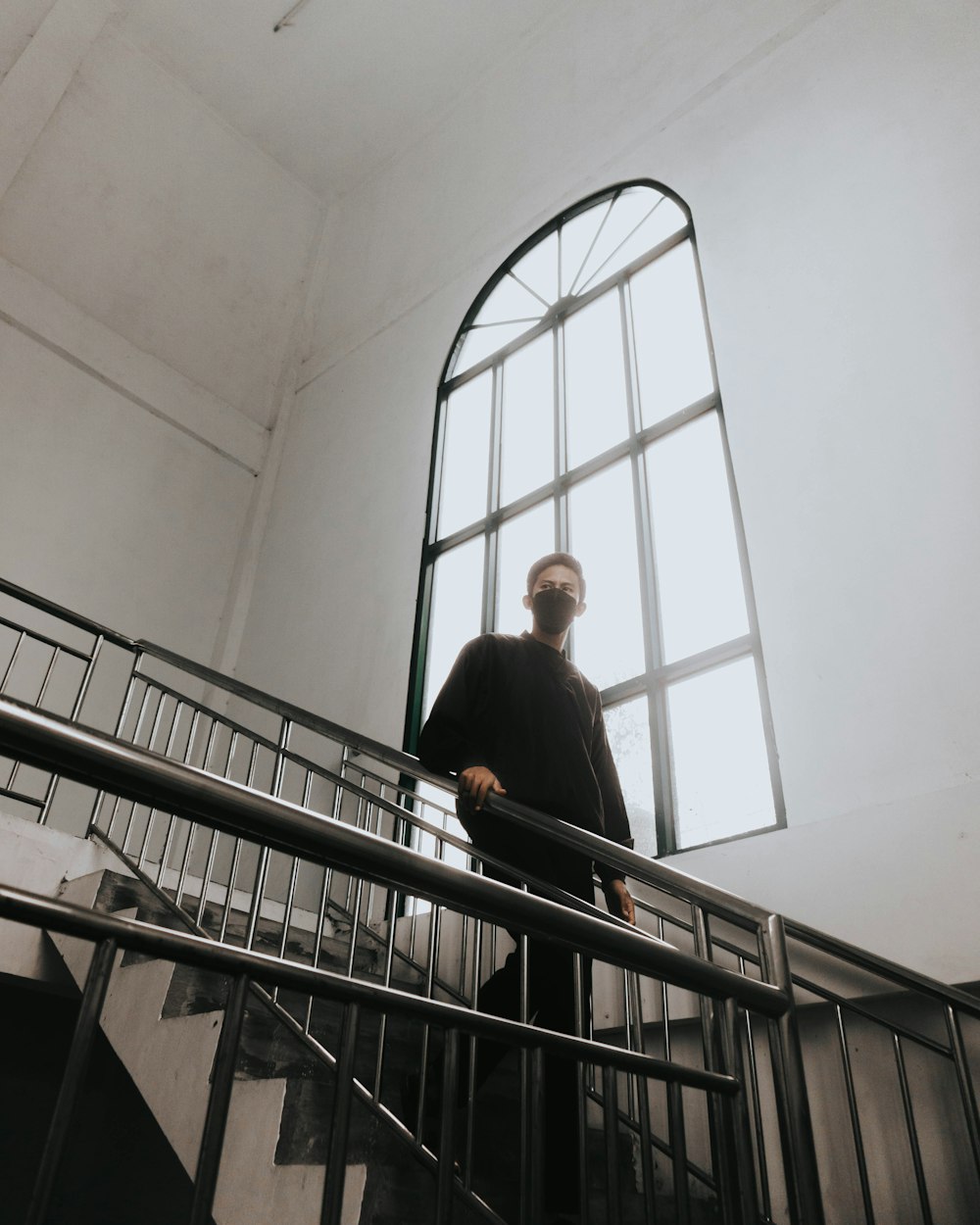 man in black suit standing on staircase