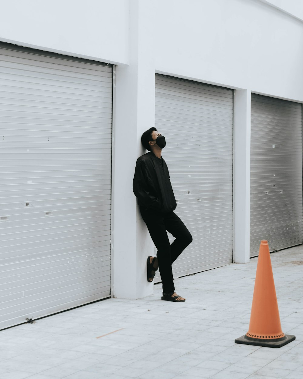 man in black suit standing near white wall