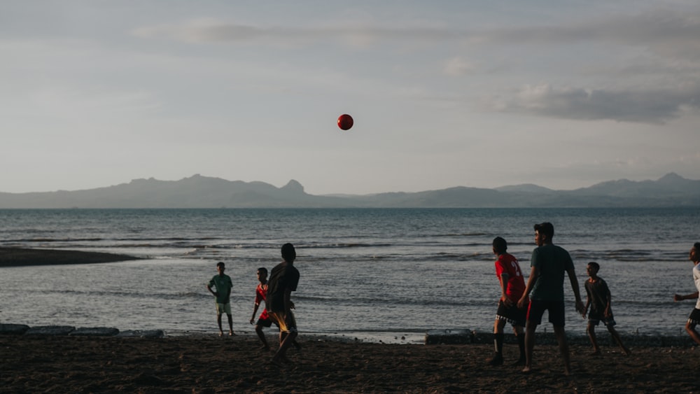 Menschen, die tagsüber am Strand Fußball spielen