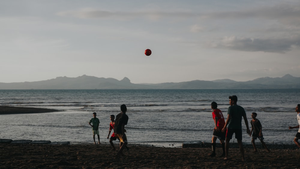 Gente jugando al fútbol en la playa durante el día