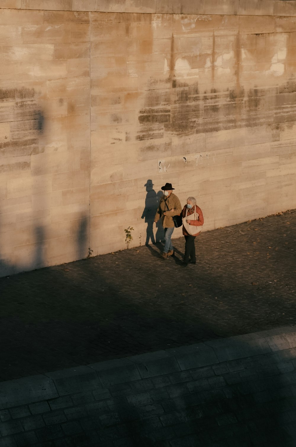 woman in black jacket and black pants walking on sidewalk during daytime