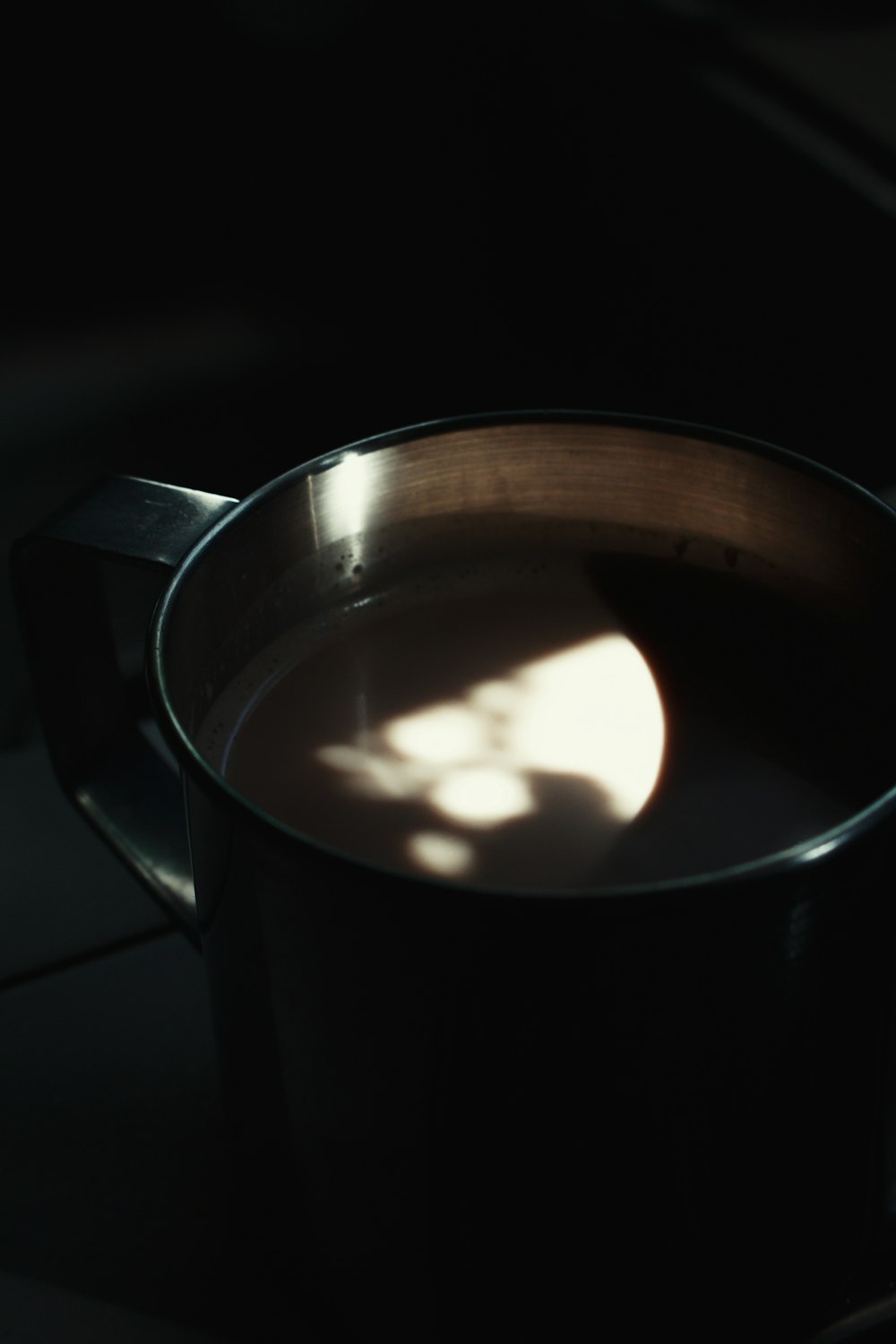 black ceramic mug with brown liquid