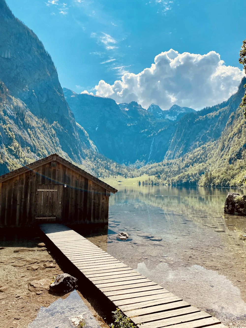 Casa de madera marrón cerca del lago y las montañas durante el día