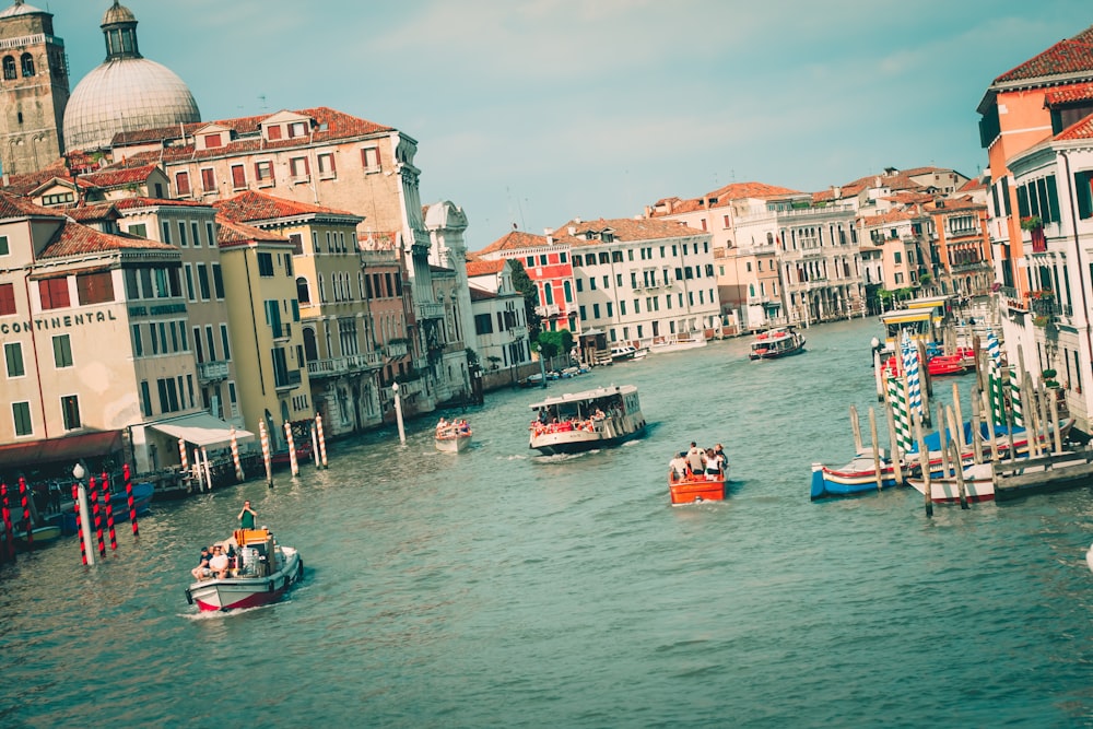 people riding on boat on river near buildings during daytime