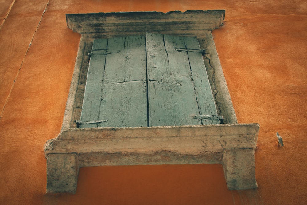 gray wooden door on orange wall