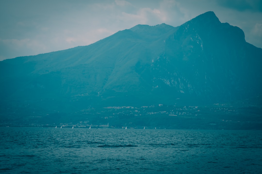 blue sea near mountain under blue sky during daytime