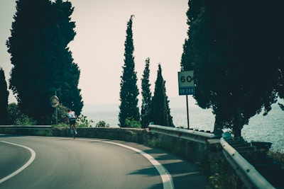 A dynamic shot of a cyclist in motion on a coastal road.
