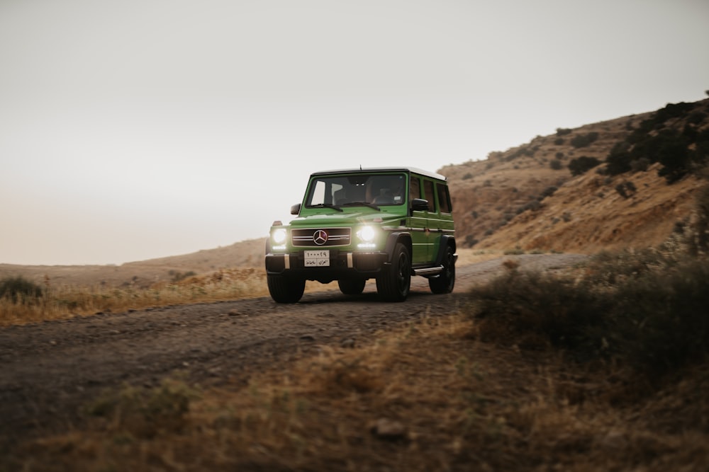 green car on brown field during daytime