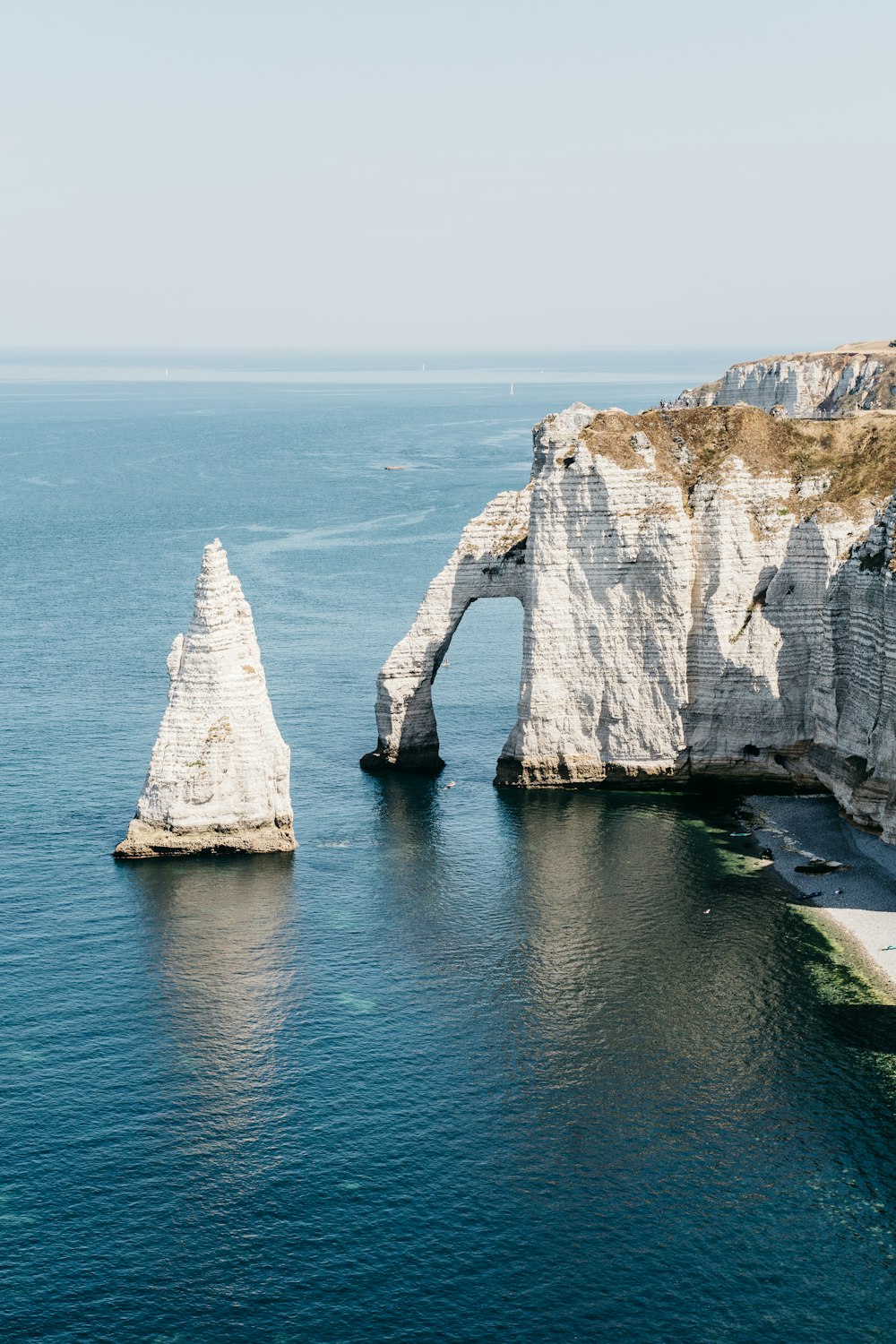 white rock formation on blue sea during daytime