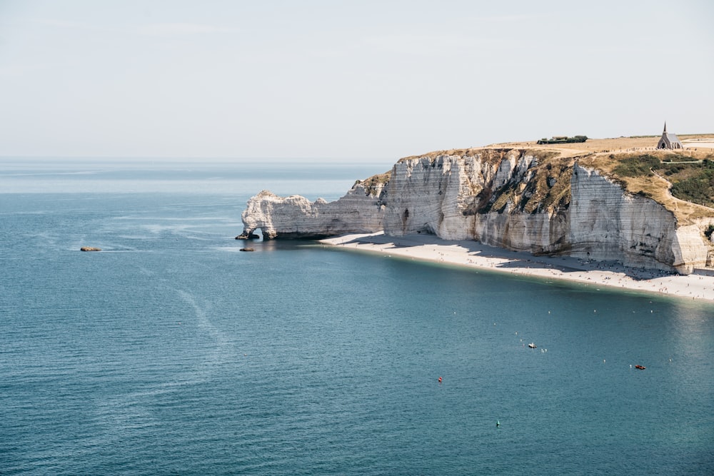 people on beach near cliff during daytime