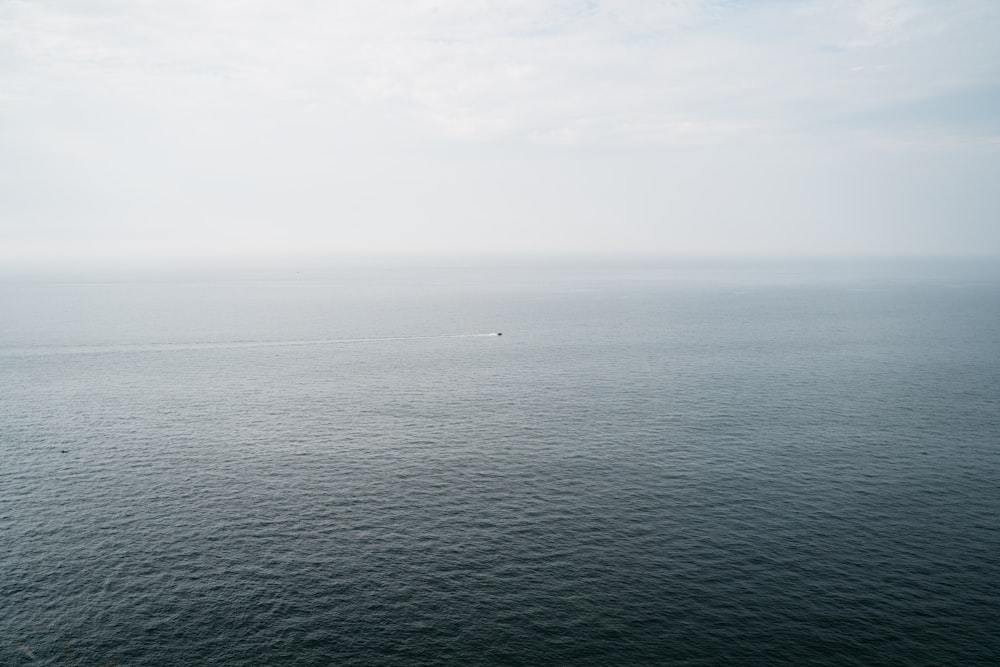 body of water under white sky during daytime