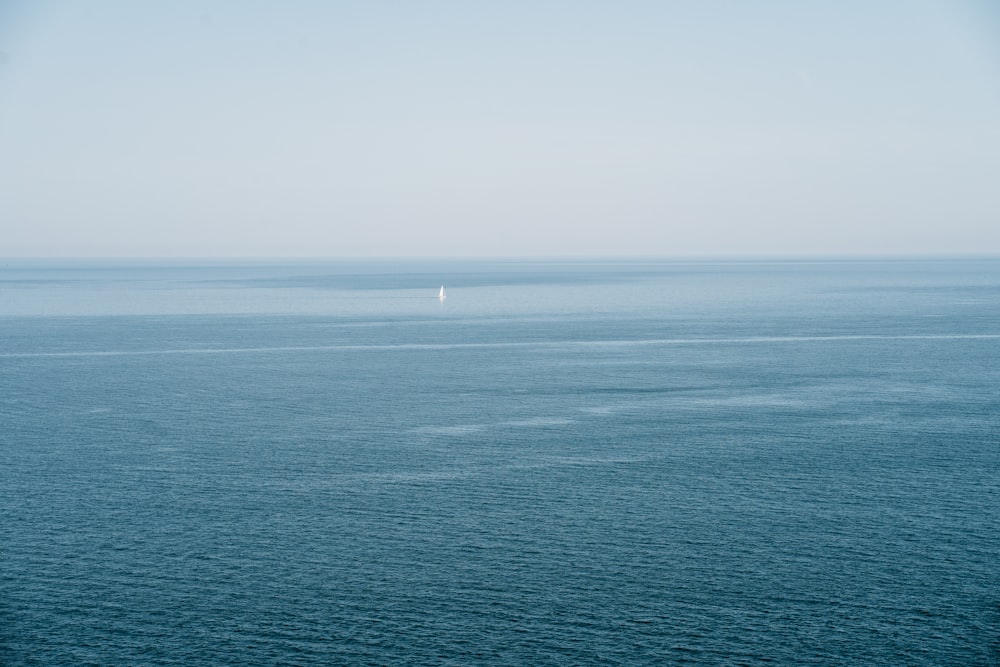 body of water under white sky during daytime