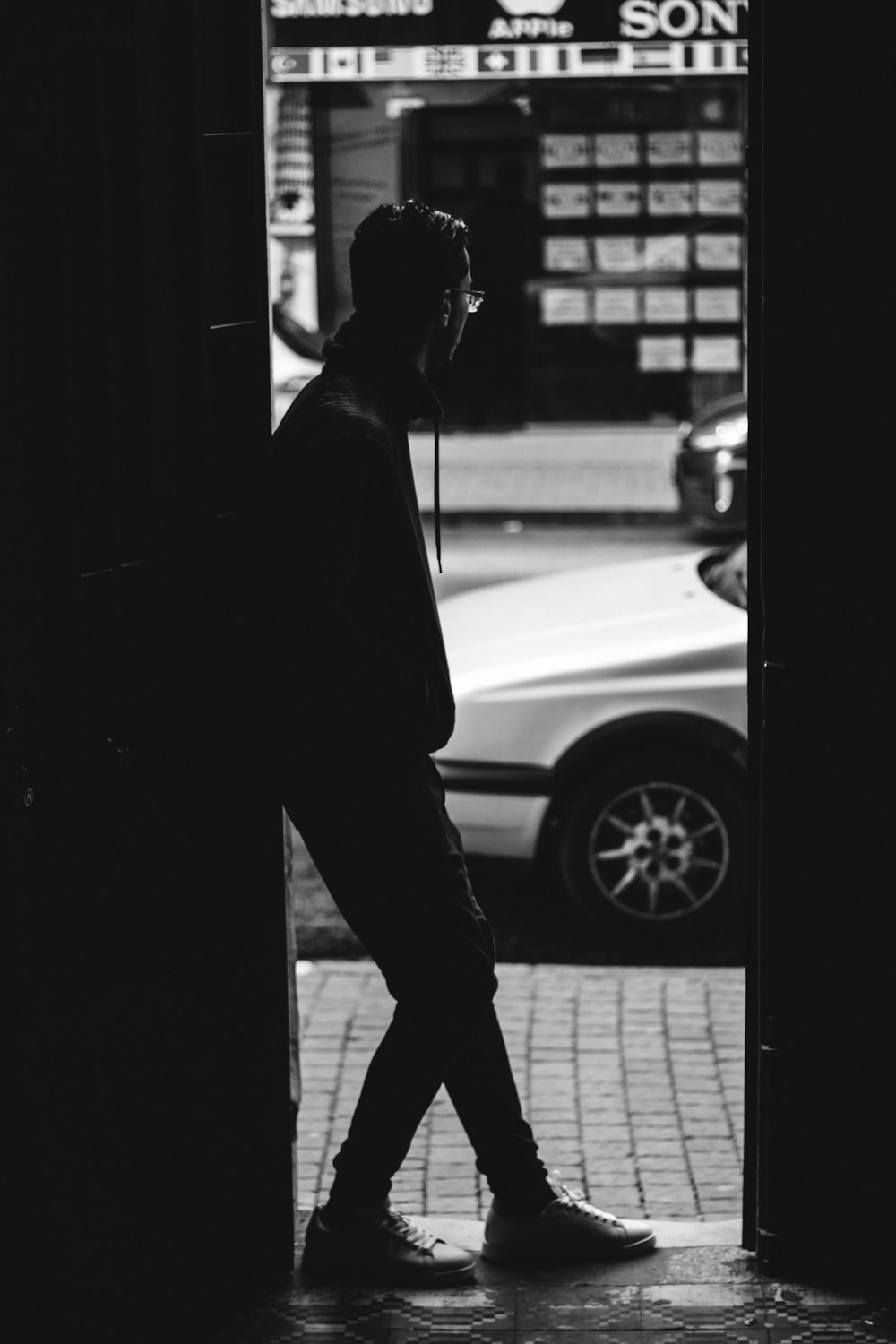 man in black suit standing on sidewalk