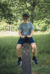 A young boy wearing cool sunglasses outdoors on a sunny day.