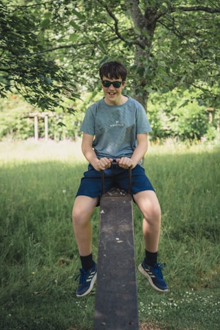 A young boy wearing cool sunglasses outdoors on a sunny day.