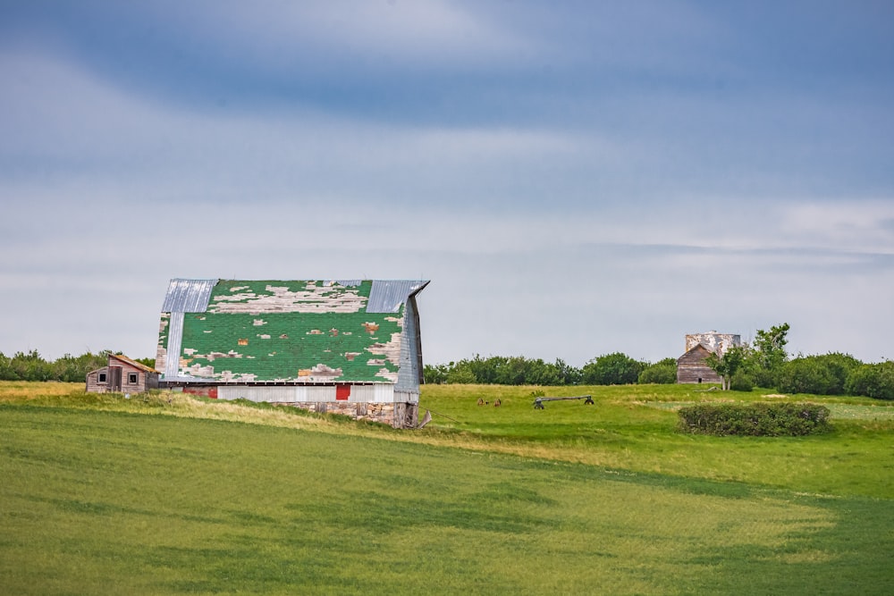 red and white barn on green grass field under blue sky during daytime