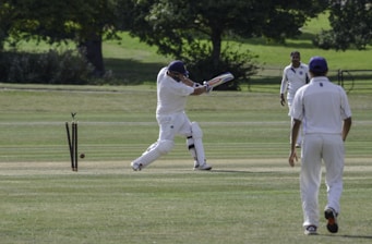 man in white shirt and pants playing golf during daytime