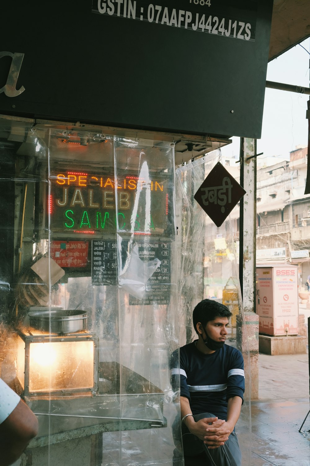 hombre con chaqueta negra de pie junto a la ventana de vidrio