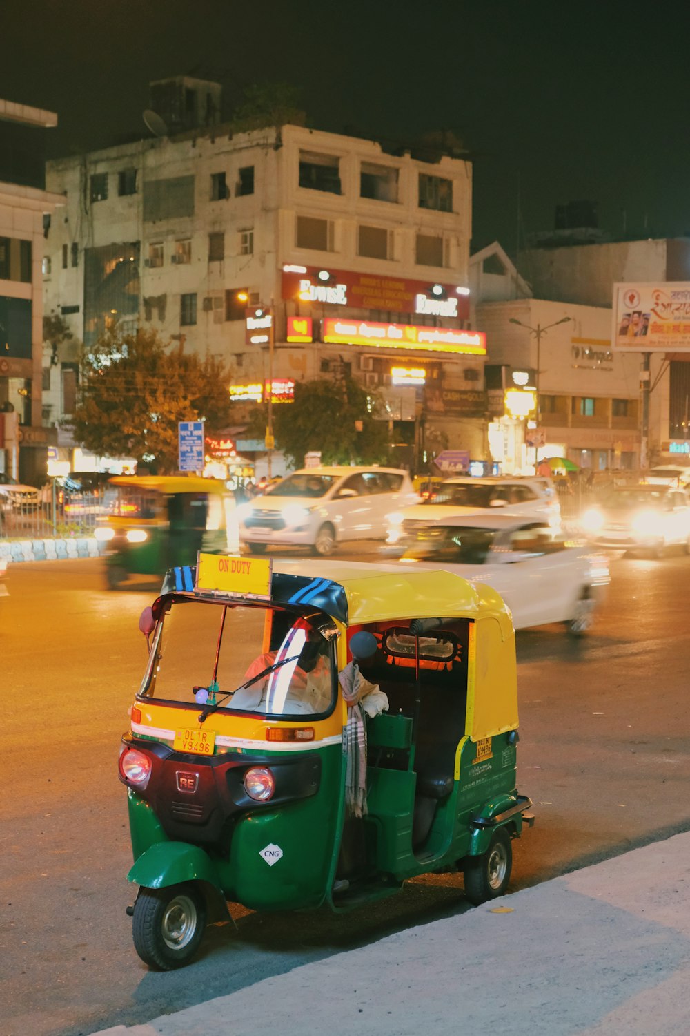 Rickshaw azul y amarillo en la carretera durante la noche