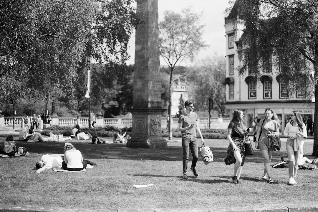 grayscale photo of people walking on park