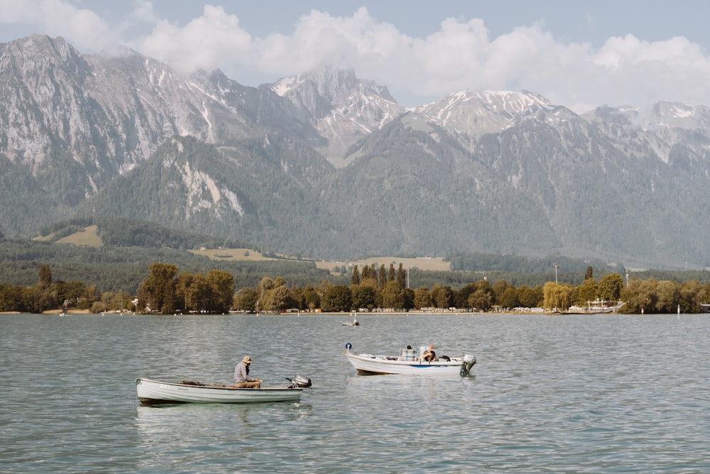 personas que viajan en un bote blanco en el lago durante el día