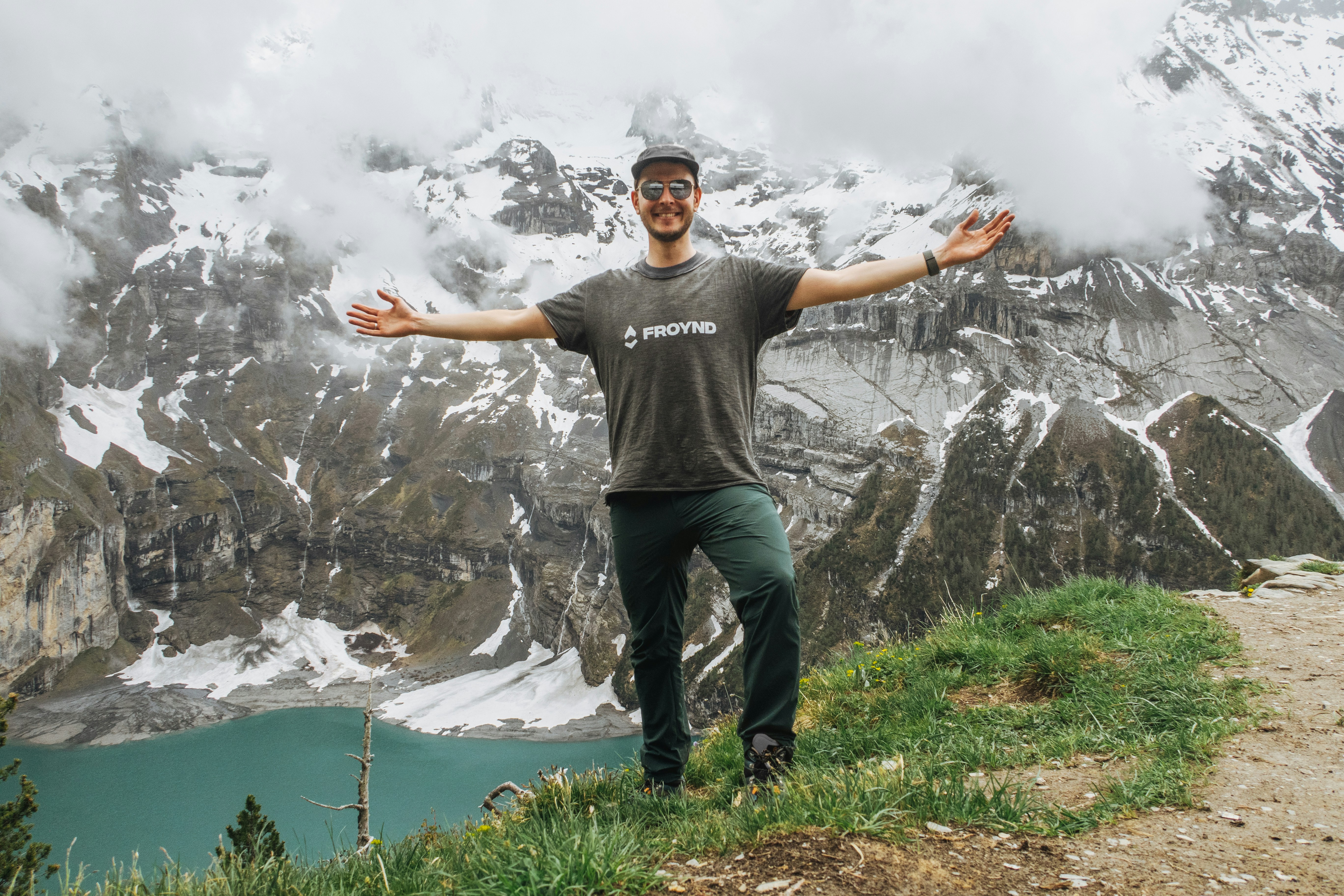 man in black crew neck t-shirt standing on green grass field during daytime
