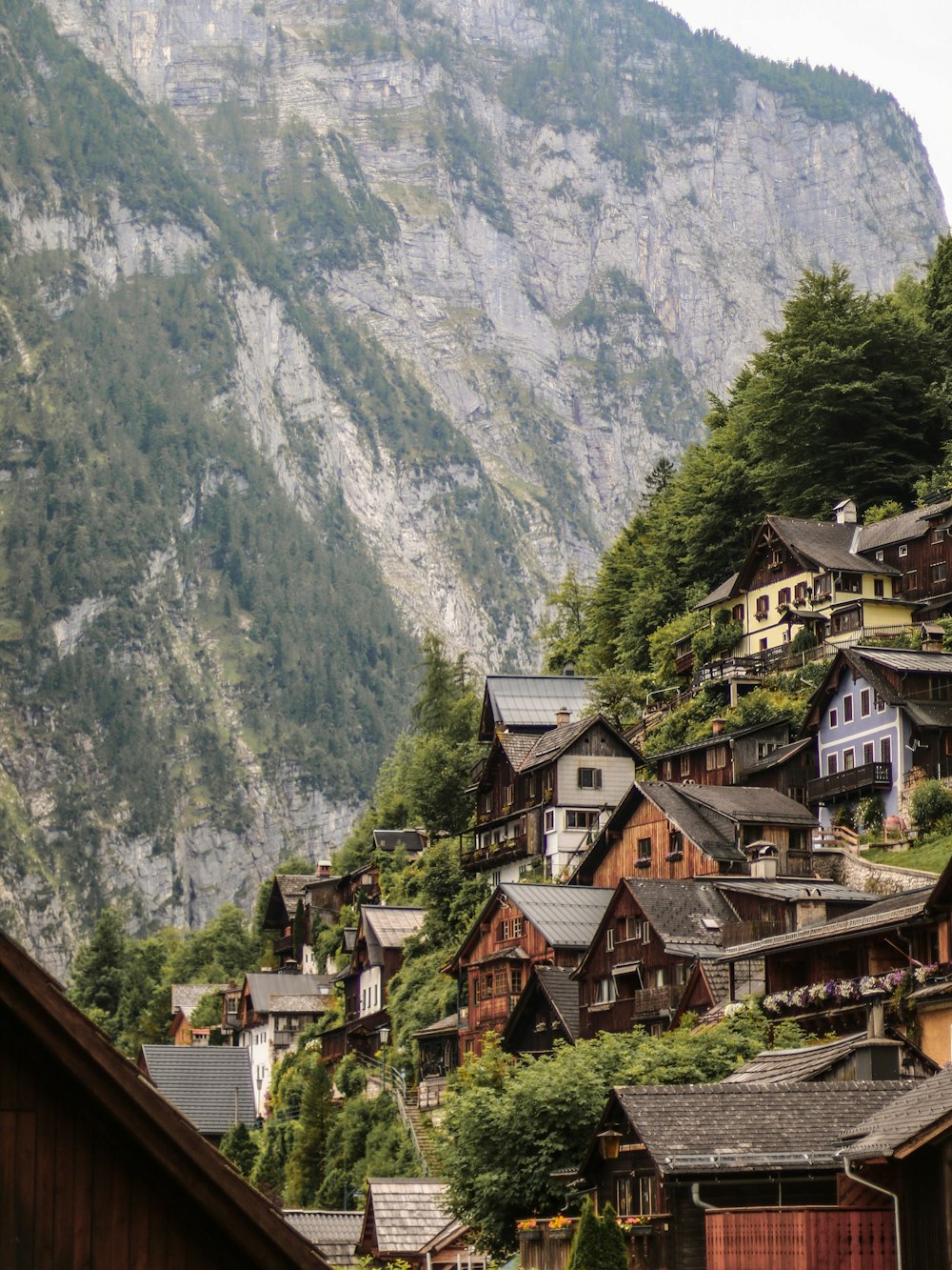 brown and green houses near mountain during daytime